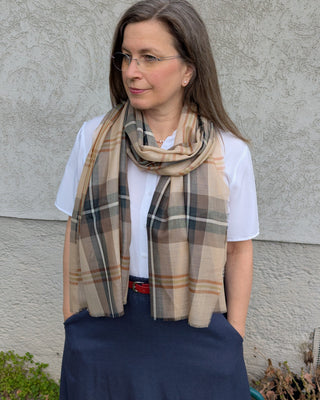 Zu sehen ist eine feine, karierte Merinostola bzw. Schal in beige und brauntönen
