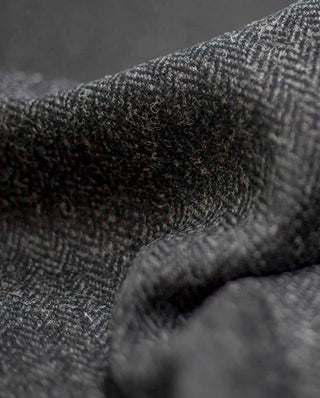 Der Harris Tweed Stoff charcoal zeigt ein dunkelgraues Fischgrätenmuster.