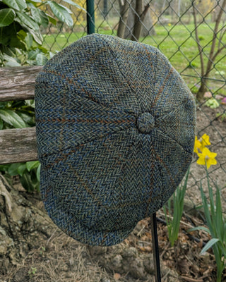 Zu sehen ist eine Ballonmütze aus Harris Tweed in Oliv- und Brauntönen