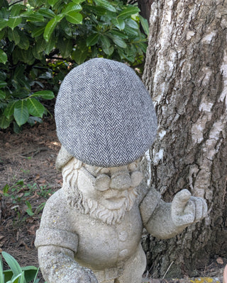 Zu sehen ist eine Schiebemütze aus Harris Tweed in Schwarzweiß
