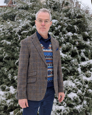 Zu sehen ist ein Zweiknopfsakko aus Harris Tweed in einer grau, braun, blauen Farbstellung. Farblich sehr vielseitig kombinierbar. 