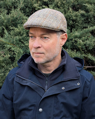 Zu sehen ist eine Schiebermütze aus Harris Tweed in einem Sandton in Dreiviertelansicht.