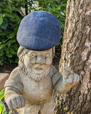 Schiebermütze aus Harris Tweed in dunkelblau mit Fäden in orange, hellgrau und mittelblau.