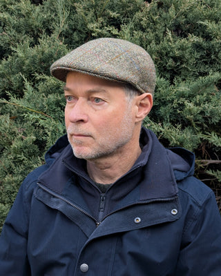 Dreiviertelansicht der Schiebermütze aus Harris Tweed in hellem Grün.
