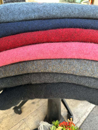 Verschiedene Capes mit Farben sind aufeinander gestapelt. Das dritte von unten ist die Farbe Moraine, typisch mit ihren goldbraune und hellbraunen Einsprengsel.