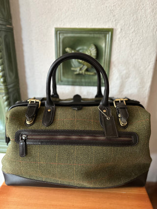 Die Doctor Bag ist von vorne abgelichtet. Der grüne Wolltweed ist mit einem Musterkaro schön gestaltet. Kombiniert ist die Tasche mit dunkelbraunem Leder. 