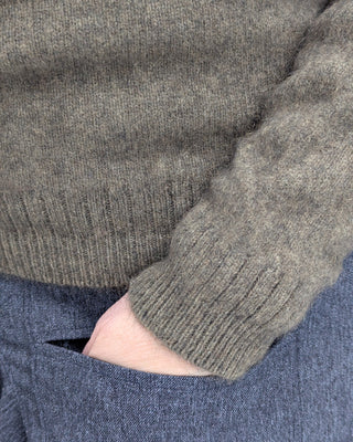 Zu sehen ist eine Strickweste aus Merino Possum mit Rundhals in der Farbe latte – beigeton. Detailansicht Bündchen Ärmel und unterer Rand