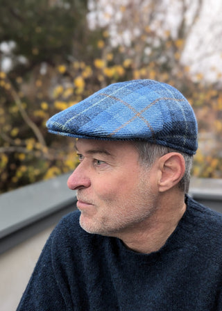 Die Harris Tweed Mütze ist von der Seite zu sehen. Gut erkennbar der Schirm, weswegen sie auch gerne als Schiebermütze bezeichnet wird.